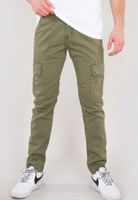 Olivgröna cargobyxor i bomull, med många fickor, slim fit-design och kombineras med vita sneakers.