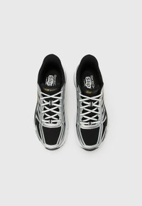 Black and silver Skechers sport sneakers with white laces, mesh fabric, and cushioned soles viewed from above on a white background.