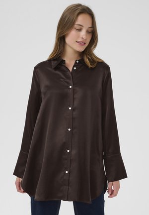 Brown satin long-sleeve shirt with a placket of white buttons, pointed collar, and flared cuffs, featuring a curved hem and smooth texture.