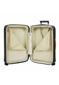 Valigia rigida blu navy con interno beige, scomparti con zip e manico retrattile; dotata di ruote scorrevoli per una facile mobilità.