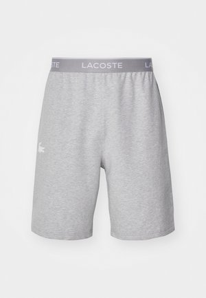Graue Shorts aus weichem Stoff mit elastischem Bund. Mit einem dezenten, weißen Logo auf der linken Seite und einem klassischen Schnitt.