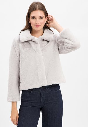 Faux fur cropped jack in lichtgrijs met een brede kraag, oversized mouwen en textuurstof; gecombineerd met donkerdenim jeans.