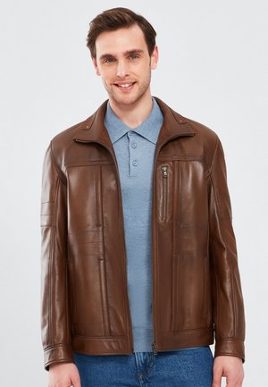 Bruine leren jas met een rits aan de voorkant, geribbelde kraag en ritszak op de borst. Heerlijke textuur, slim fit en zijnaden met stikdetails.