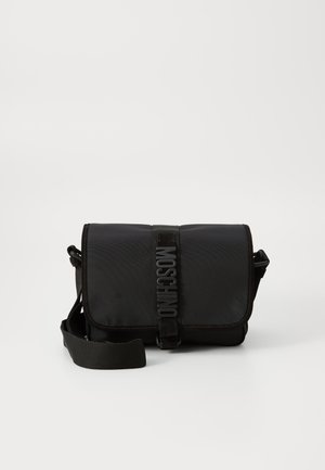 Schwarze Nylon-Crossbody-Tasche mit Klappe, ausgestattet mit einem auffälligen Logo-Gurtverschluss, verstellbarem Tragegurt und seitlichen Steppnähten.