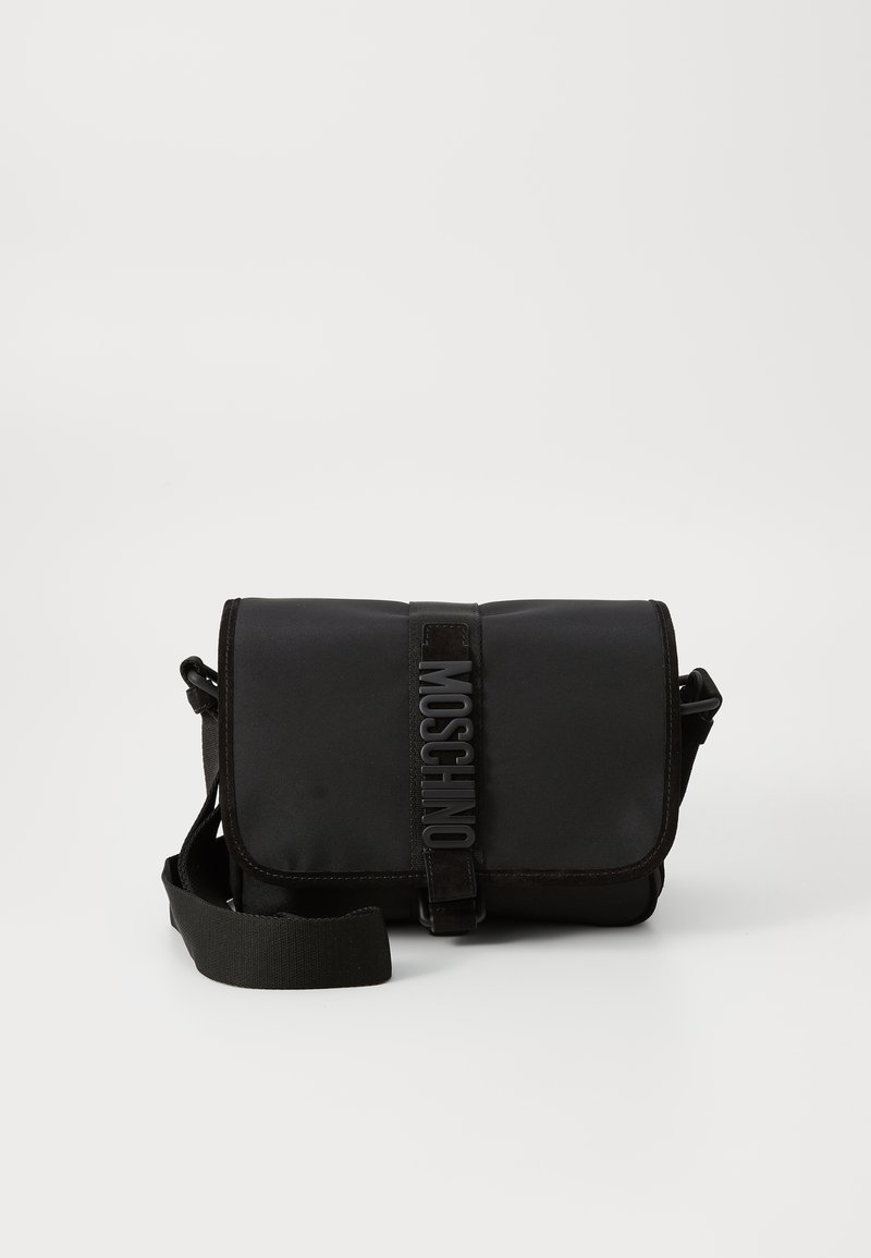 Borsa a tracolla nera in nylon con patta, dotata di un evidente sistema di chiusura con cintura logo, tracolla regolabile e dettagli di cucitura laterale.