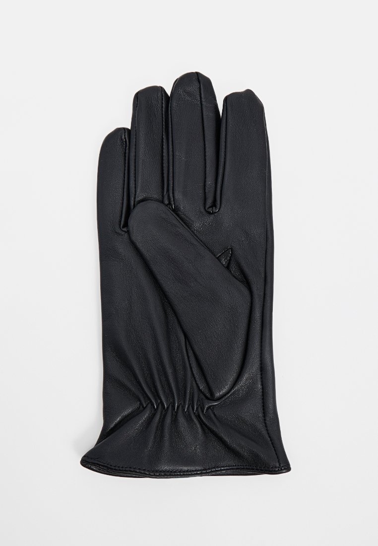 Schwarze Lederhandschuhe mit gerafftem Handgelenk, flach mit der Handfläche nach oben auf einem weißen Hintergrund gezeigt.