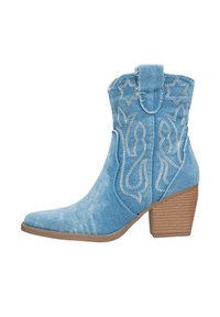 Botines de mezclilla azul con punta afilada, tacón bloque beige y patrones florales y estrellados bordados en blanco en el eje.