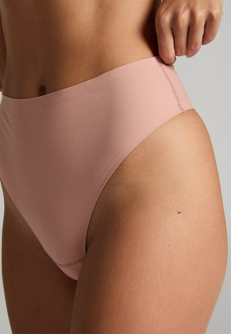 Hochgeschnittene Bikinihose aus weichem pinkfarbenem Stoff mit glatter Textur und minimalen Nähdetails. Gestaltet, um Bedeckung zu bieten.