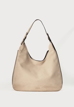 Beige læder skuldertaske med en enkelt justerbar rem og et diskret logo i guldfarve på frontens centrum.