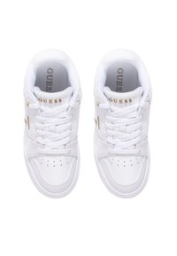 Hvide sneakers med en glat læderoverflade, rund tå og guld "GUESS"-logo på siden. Har teksturerede snørebånd og perforerede detaljer.