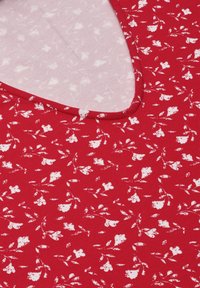 Czerwona tkanina z drobnym białym kwiatowym wzorem i zaokrąglonym dekoltem, ukazującym jasno-różową podszewkę z subtelnym kwiatowym motywem.