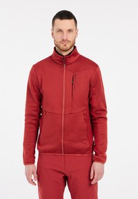 Rode zip-up jas met hoge kraag, textuurpanelen en zijzakken. Gemaakt van een gladde, flexibele stof, met een fitted ontwerp.