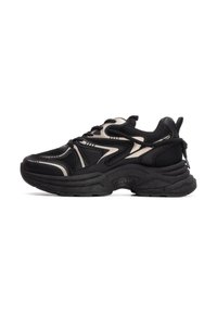 Zapatillas deportivas negras con parte superior de malla y acentos en negro y beige, una entresuela de goma gruesa y un collar acolchado para mayor soporte.