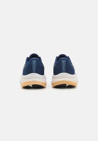 Marine hardloopschoenen hebben een ademende bovenkant van mesh, een witte tussenzool met gelkussen, en een zwarte rubberen zool, ontworpen voor comfort en ondersteuning.