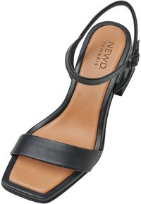 Sandal con tacco alto in pelle nera, con retro aperto, ampia fascia anteriore e cinturino alla caviglia. Soletta color marrone chiaro con dettaglio del logo impresso.