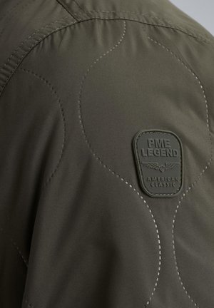 Quilted green jacket featuring a textured surface, rounded stitching details, and a black rubber logo patch labeled "PME LEGEND AMERICAN CLASSIC."