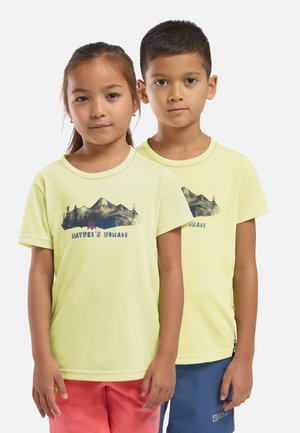 Deux enfants se tiennent côte à côte, portant des t-shirts jaunes clairs assortis "Nature's Nomads" avec des motifs de montagnes et d'arbres.