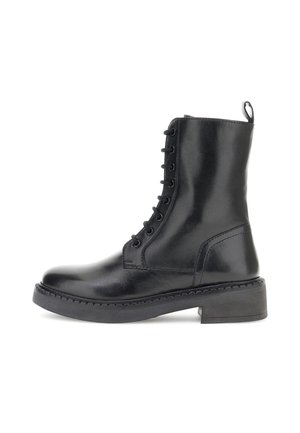 Botine din piele negre, până la glezne, cu șireturi, talpă groasă din cauciuc și buclă în spate, văzute din lateral pe un fundal alb.