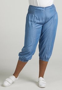 Vaaleansinisiä, lyhyitä, joustovyötäröisi ä housuja pehmeästä kankaasta. Ominaisuuksiin kuuluu rypytetty vyötärö ja koottu hihna, mikä tarjoaa rentoa istuvuutta.