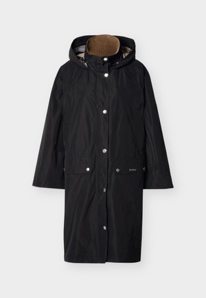Imperméable long noir à capuche avec boutons-pression, poches avant, et une doublure beige à l'intérieur du col, étalé à plat sur un fond clair.