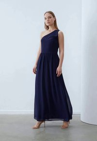 Vestido maxi azul marino de un solo hombro en tejido ligero. Cuerpo ajustado con una cintura fruncida, falda fluida y textura de superposición transparente.