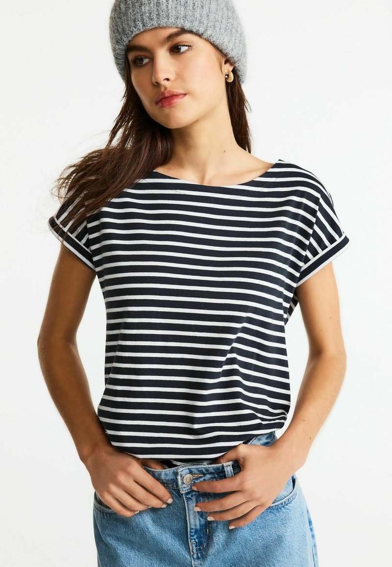 Marinblå och vit randig t-shirt med kort ärm och båtstångsdesign, tillverkad av mjukt tyg, ihop med högmidjade denimshorts.