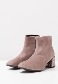 Szare zamszowe botki za kostkę o gładkim wykończeniu, z wzorzystym słupkowym obcasem i bocznym zamkiem błyskawicznym dla łatwego zakładania.