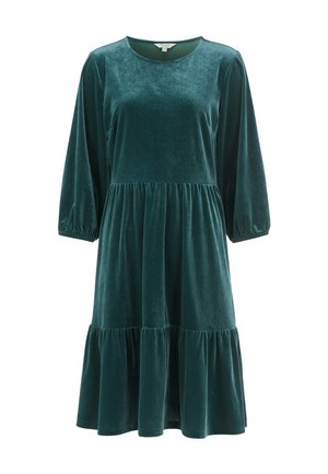 Sammet grön klänning med rund halsringning, långa ärmar och lager-på-lager, utsvängd kjol. Mjuk textur med elastiska manschetter vid ärmarna.