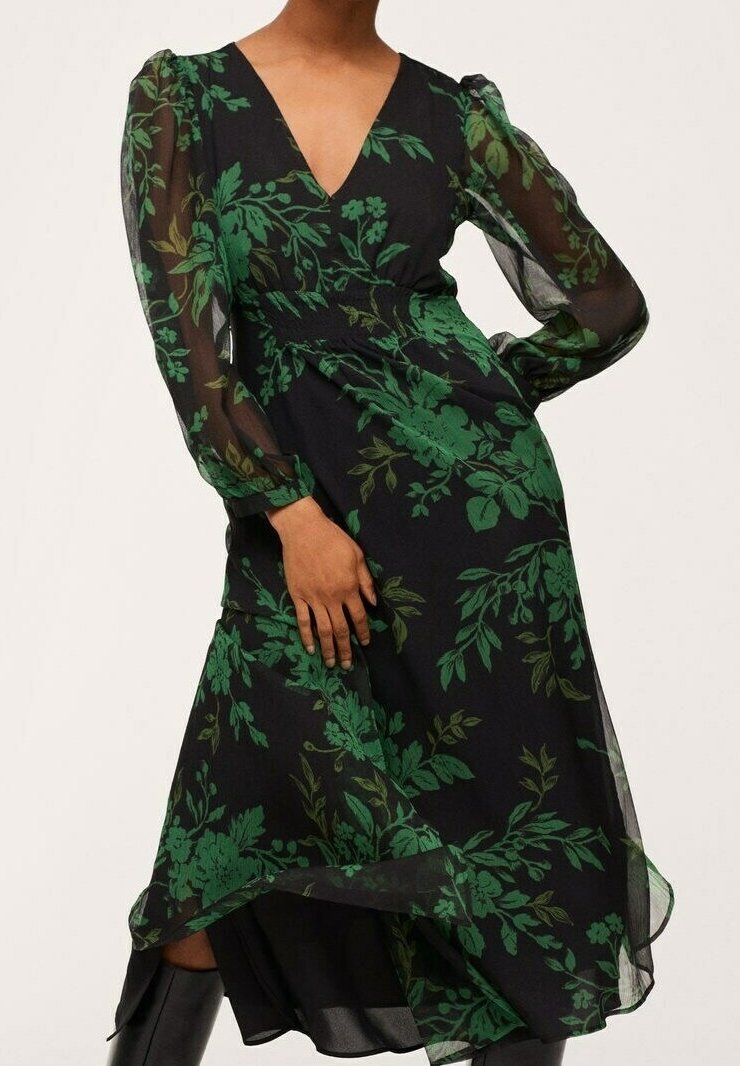 Robe noire à motifs floraux avec des manches longues transparentes, un décolleté en V et une taille cintrée. Motifs botaniques verts dominants sur l'ensemble.