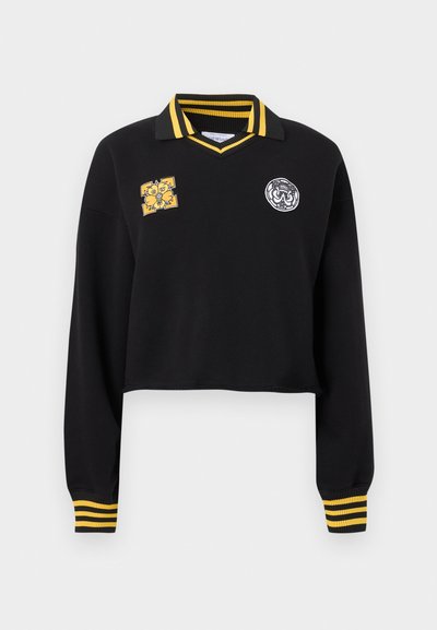 Μαύρο cropped πουλόβερ πόλο με μακριά μανίκια, με μανσέτες και γιακά με κίτρινες ρίγες. Διαθέτει δύο διακοσμητικά μπαλώματα στο μπροστινό μέρος. Ομαλή υφή.