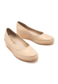 Beżowe skórzane buty na koturnie z okrągłym noskiem, teksturowanym wierzchem, subtelnymi perforacjami i naturalną, drewnopodobną podeszwą. Lekka konstrukcja zapewniająca komfort.