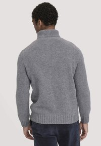 Grau gestrickter Pullover mit hohem Kragen, gerippten Bündchen und geripptem Saum; weiche, strukturierte Oberfläche; Ansicht von hinten, mit dunkler Hose.