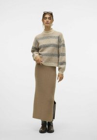 Beige gebreid sweater met donkerblauwe strepen en een ronde hals, gecombineerd met een lange beige rok en bruine enkellaarsjes. Gladde textuur.