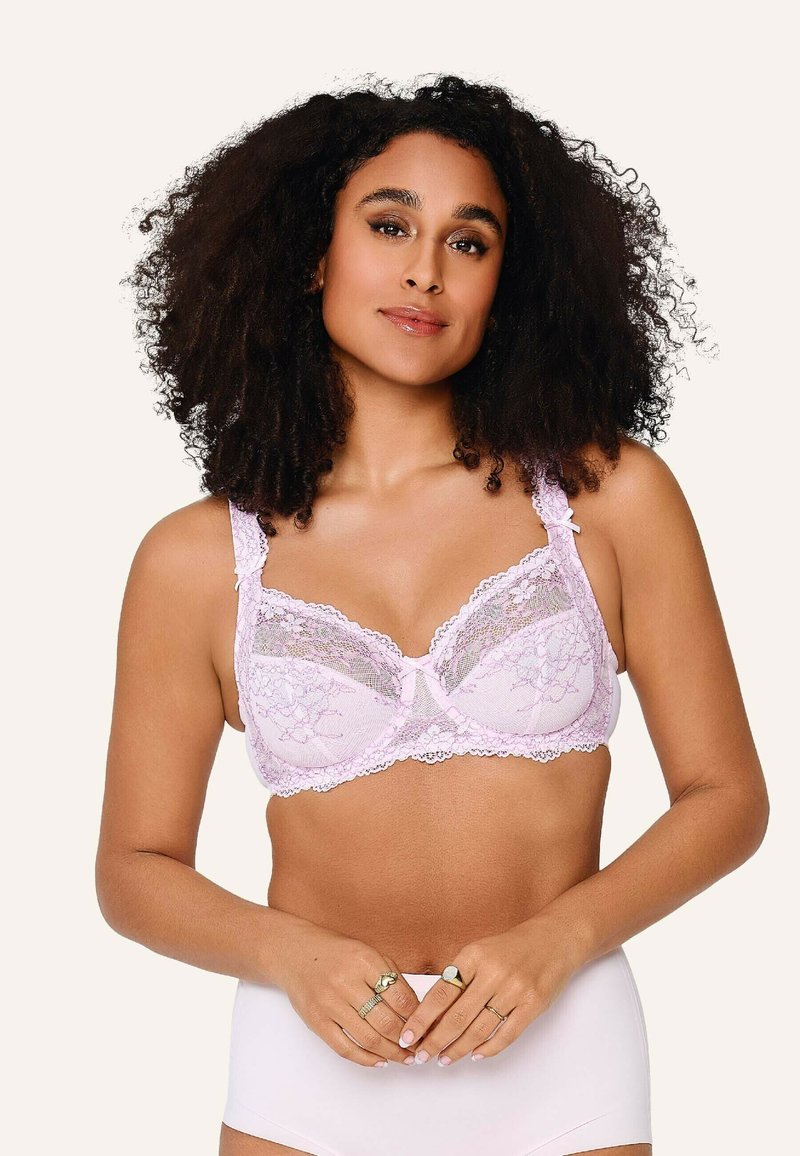 Lace beha in zachtroze met bloemmotief en gegolfde randen; heeft brede, verstelbare bandjes en een klein strikje in het midden.