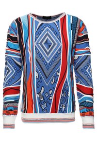Pull en maille présentant un motif géométrique vibrant en bleu, rouge et noir, avec un col rond et des poignets et un ourlet côtelés contrastants.