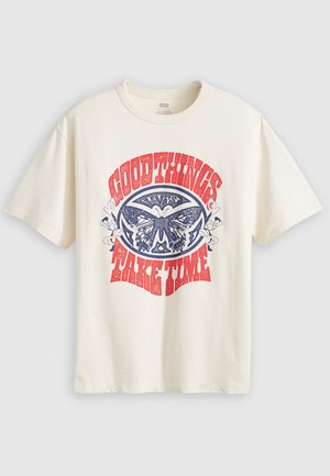 Cream cotton t-shirt featuring a blue and red butterfly graphic with the text “Good Things Take Time” in stylized lettering. Short sleeves.