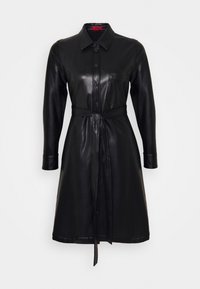 Černé kožené šaty košile s límcem, předními knoflíky, dlouhými rukávy a páskem v pase. Obsahuje jednu náprsní kapsu a hladký povrch.