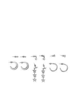 Six paires de boucles d’oreilles argentées, clous et anneaux, disposées en deux rangées, comprenant de petits clous, des pendants en forme d’étoile et des anneaux texturés.