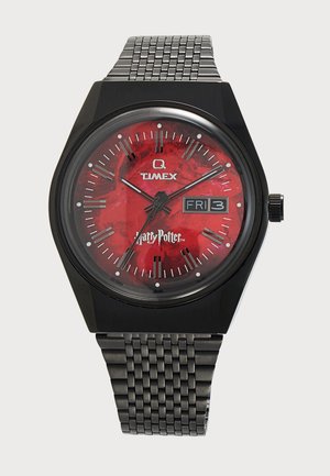 Черна метална ръчен часовник Timex с червен циферблат на тема Хари Потър, сребристи часови маркери и дисплей за ден и дата, показващ петък, 3-ти.