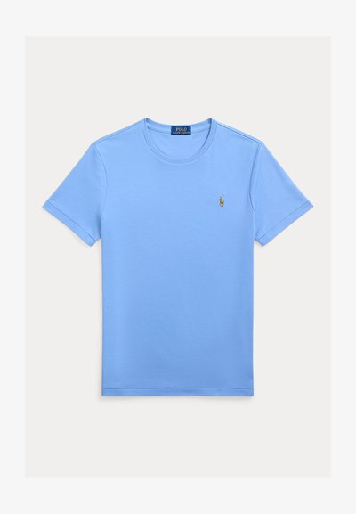 Šviesiai mėlynas medvilninis marškinėlis su apvalia apykakle, trumpomis rankovėmis ir mažu siuvinėtu logotipu kairėje krūtinės pusėje. Lygi tekstūra.