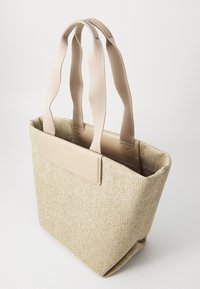 Bolso tote tejido en color beige con asas suaves, que presenta un panel marrón claro en el frente. Diseño de abertura superior con un interior espacioso.
