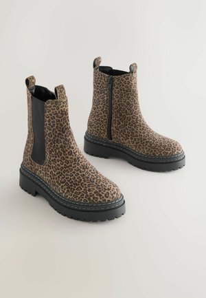 Ankelové topánky s leopardím vzorom vyrobené z textúrovaného materiálu, ktoré majú elastické bočné panely, čiernu gumovú podrážku a bočný zips pre jednoduché obúvanie.