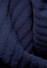 Navy blue ribbed fabric with a soft, textured surface. Features deep grooves and a slight sheen, indicating a cozy, thick material.