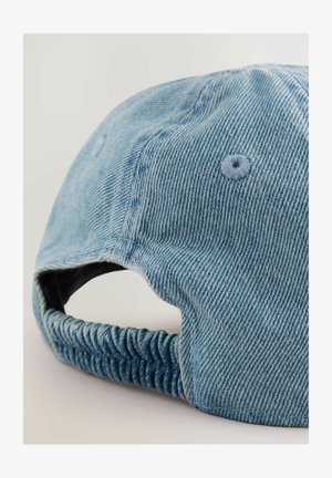 Denimkappe in hellblau mit einem gebogenen Schirm, gerüschtem elastischen Rücken und genähten Details. Die Textur ist gerippt und das Innenfutter ist glatt.