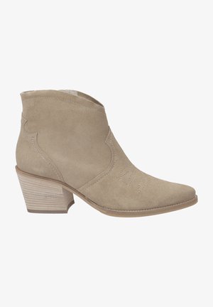 Botte de cheville en daim beige avec un bout pointu, un col angulé, des coutures décoratives et un talon empilé. Texture lisse avec une finition mate.