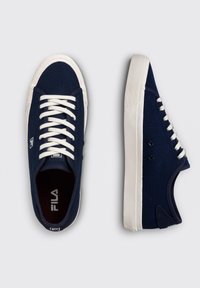 Sneakers in tela blu con suole in gomma bianche, dotati di lacci bianchi, punta con texture e logo Fila sulla linguetta.