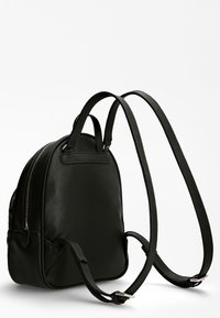 Sac à dos en cuir noir avec des straps réglables, forme arrondie, poche zippée à l'avant et texture lisse. Présente des accents en métal argenté.