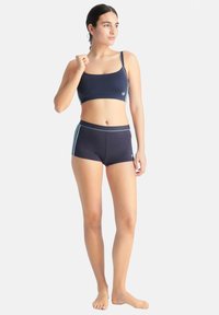 Marinblå sportig crop top med tunna axelremmar och ljusblå detaljer, matchad med marinblå shorts med blå sidränder och elastisk midja.