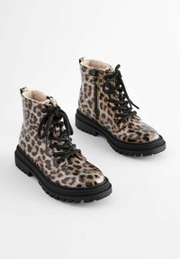 Botines de piel de leopardo en negro y marrón con forro de piel sintética, cuentan con cordones negros, cremallera lateral y una suela gruesa y robusta en negro.