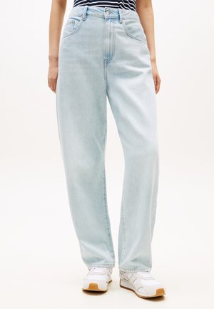 Svetlomodré rifle s vysokým pásom z rifľoviny, s rovnými nohavicami, päťvreckovým dizajnom a jemným vyblednutím. Kombinované s bielymi teniskami.